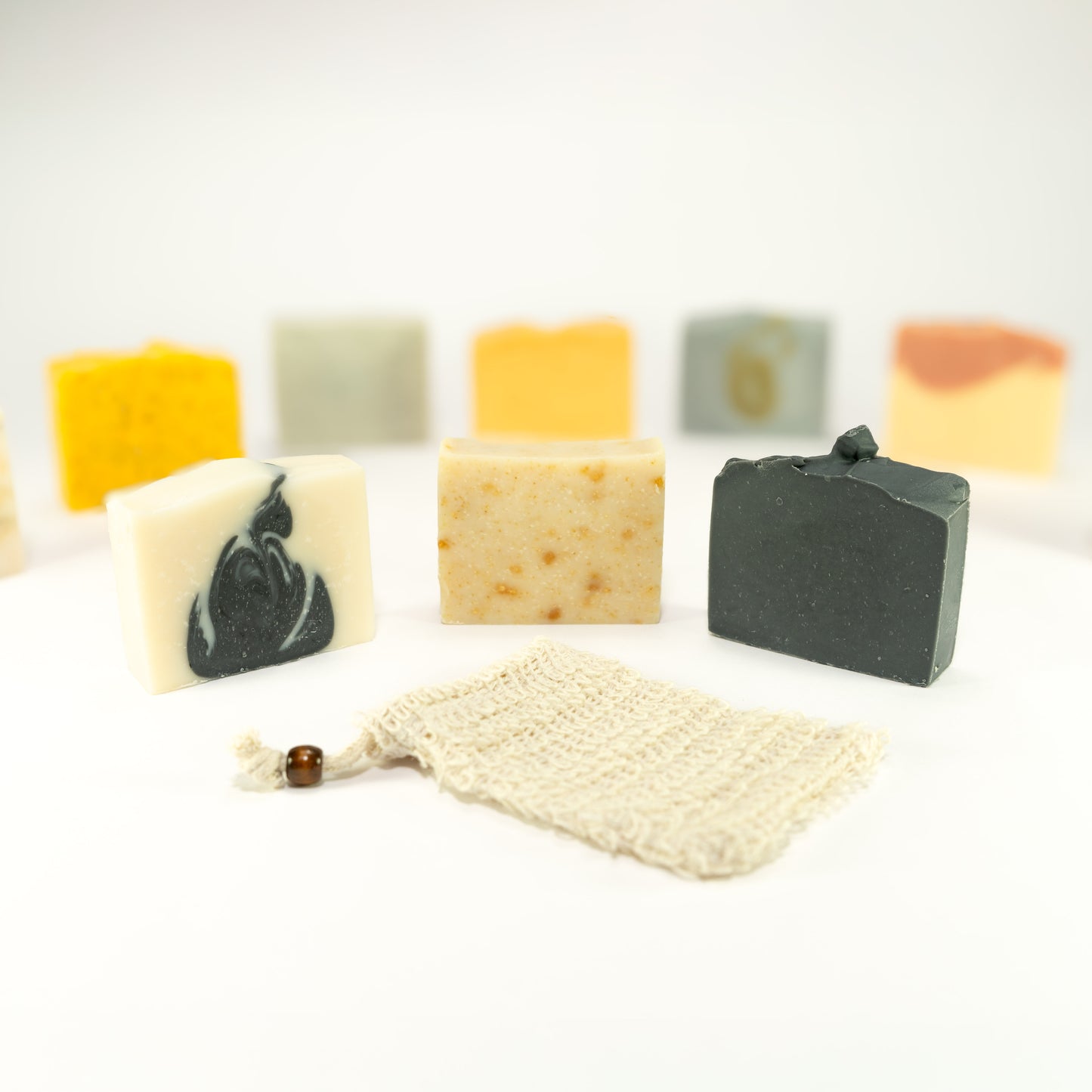 three all natural tallow soap bars with pouch and an array of colorful natural soap bars